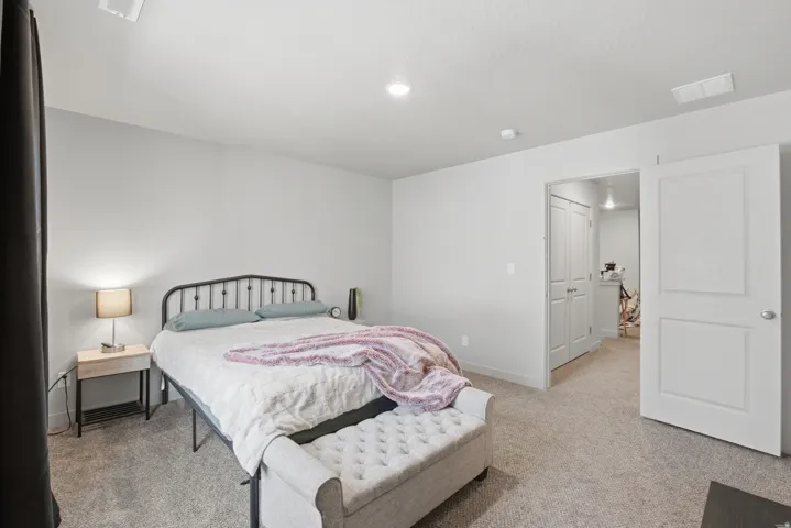 Carpeted bedroom featuring light gray walls, white trim, and recessed ceiling lighting