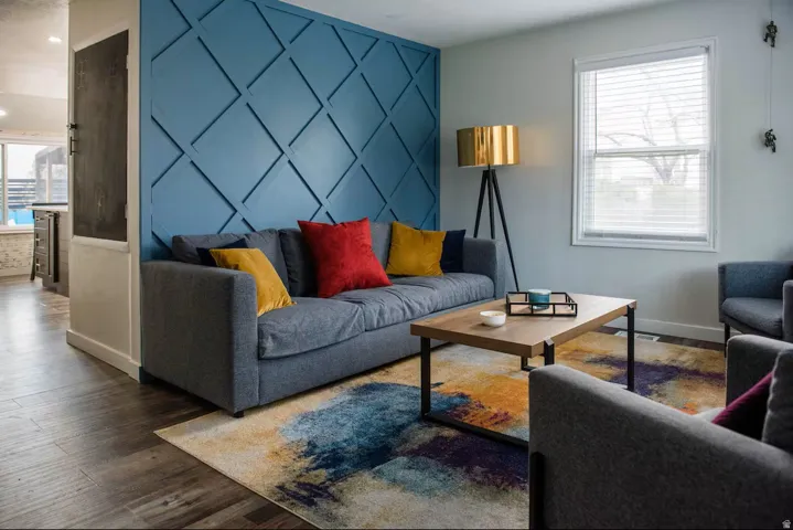 Decorative wall paneling, wood-finish flooring, ample natural light, modern ceiling lighting, and a built-in chalkboard