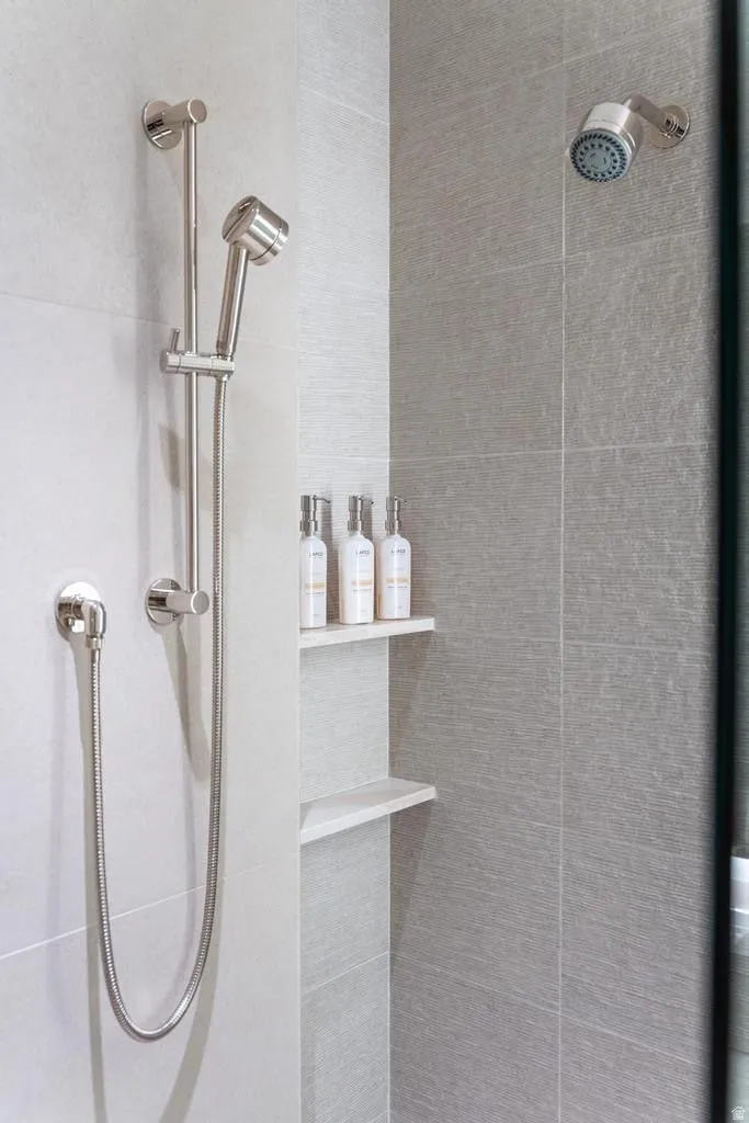Shower with a handheld spray unit, a fixed shower head, and a recessed shelving niche