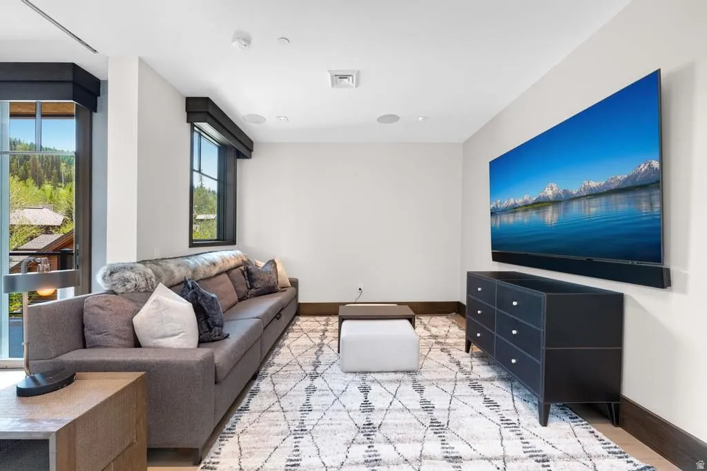 Spacious entertainment area featuring abundant natural light, recessed lighting, and a large wall-mounted display