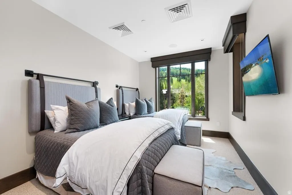 Dual beds with upholstered headboards and integrated wall-mounted lighting