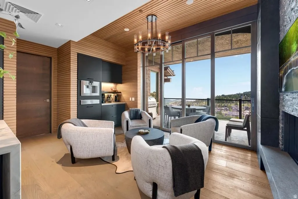 Contemporary living area featuring wood-finish flooring, a wood-slat accent ceiling, and a built-in wet bar with dark cabinetry