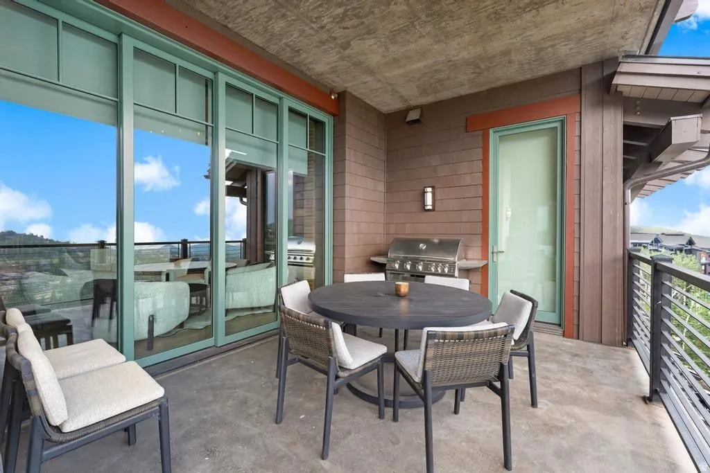 Outdoor patio featuring a built-in grill, concrete flooring, and metal railings