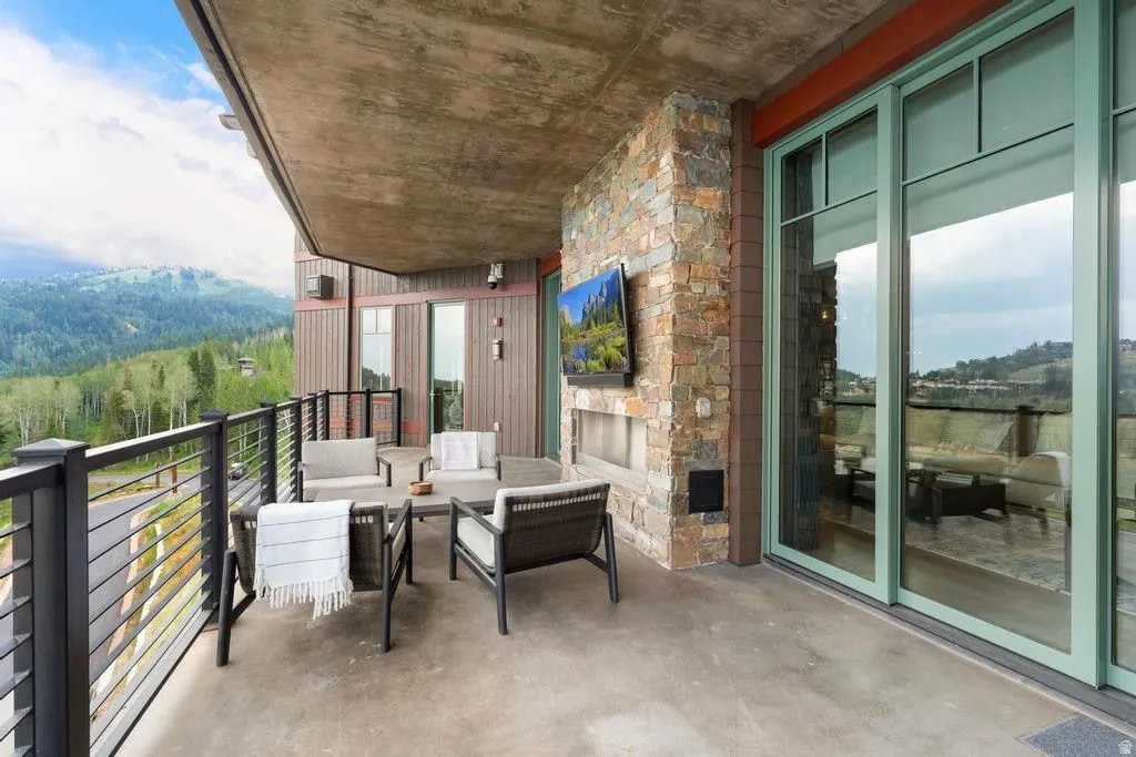 Expansive outdoor terrace featuring a stone-clad wall with an integrated fireplace