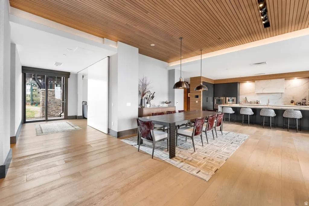 Open concept living space featuring light wood-finish flooring, a wood-slat ceiling, and recessed lighting