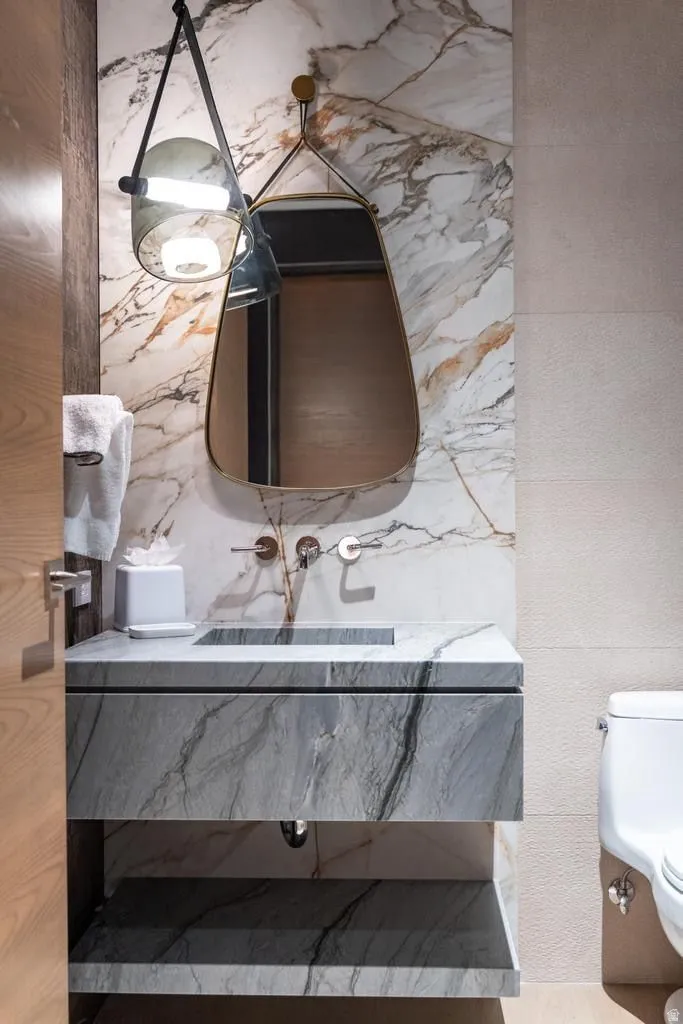 Modern vanity featuring a integrated rectangular sink, wall-mounted faucet, and a floating shelf