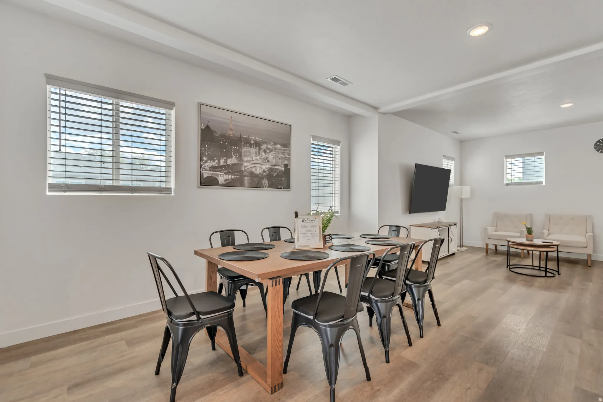 Open concept living area featuring recessed lighting, light wood-finish flooring, and multiple windows with blinds