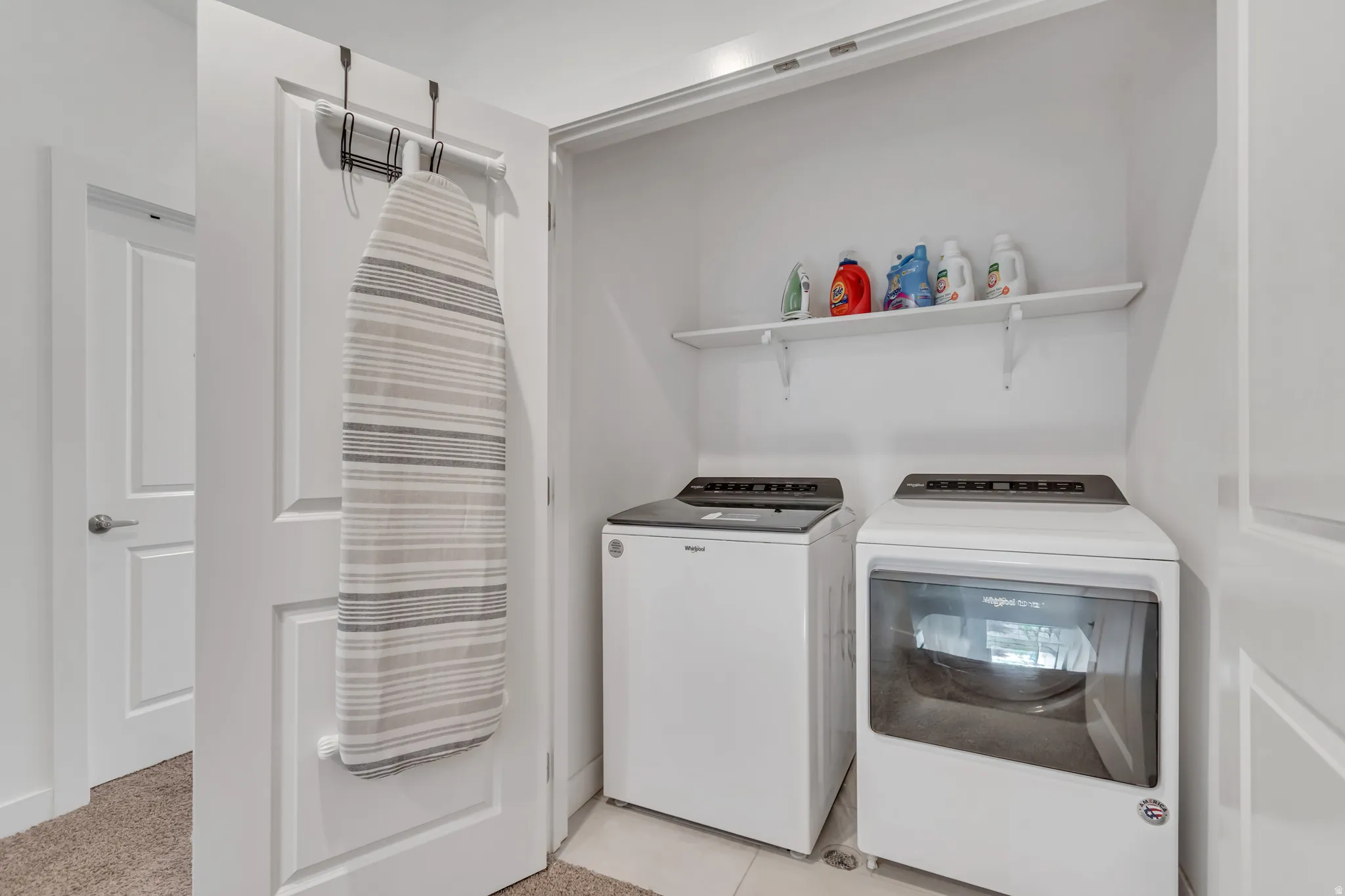 Dedicated laundry area featuring a white top-load washer and front-load dryer