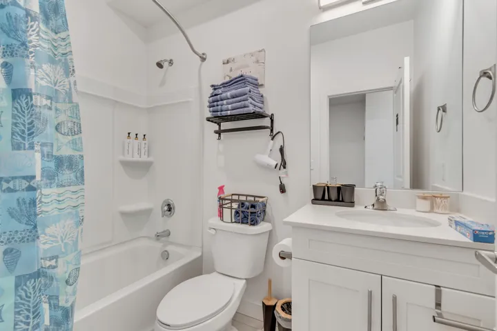 Bright bathroom featuring a white vanity with an undermount sink, a large wall-mounted mirror, and a chrome faucet