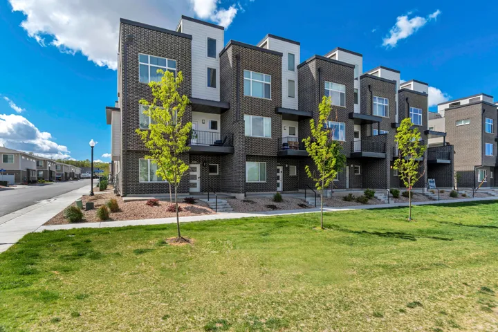 Modern townhome-style residences featuring dark brick and light siding exteriors