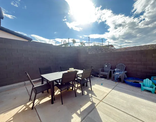 Concrete patio area featuring a block wall surround
