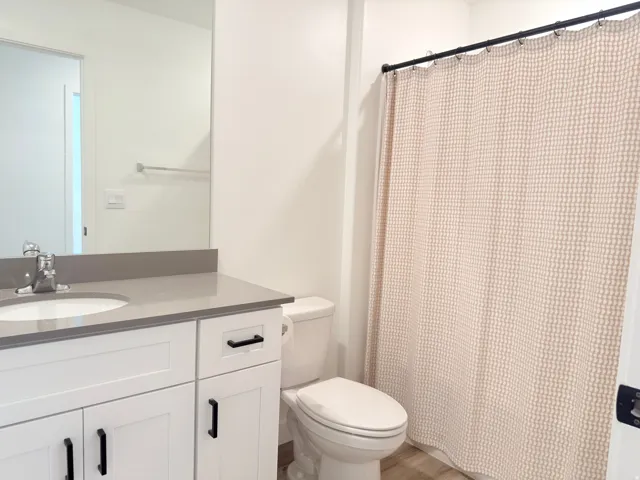 Bathroom featuring a white vanity with black hardware, a light gray countertop, and an undermount sink