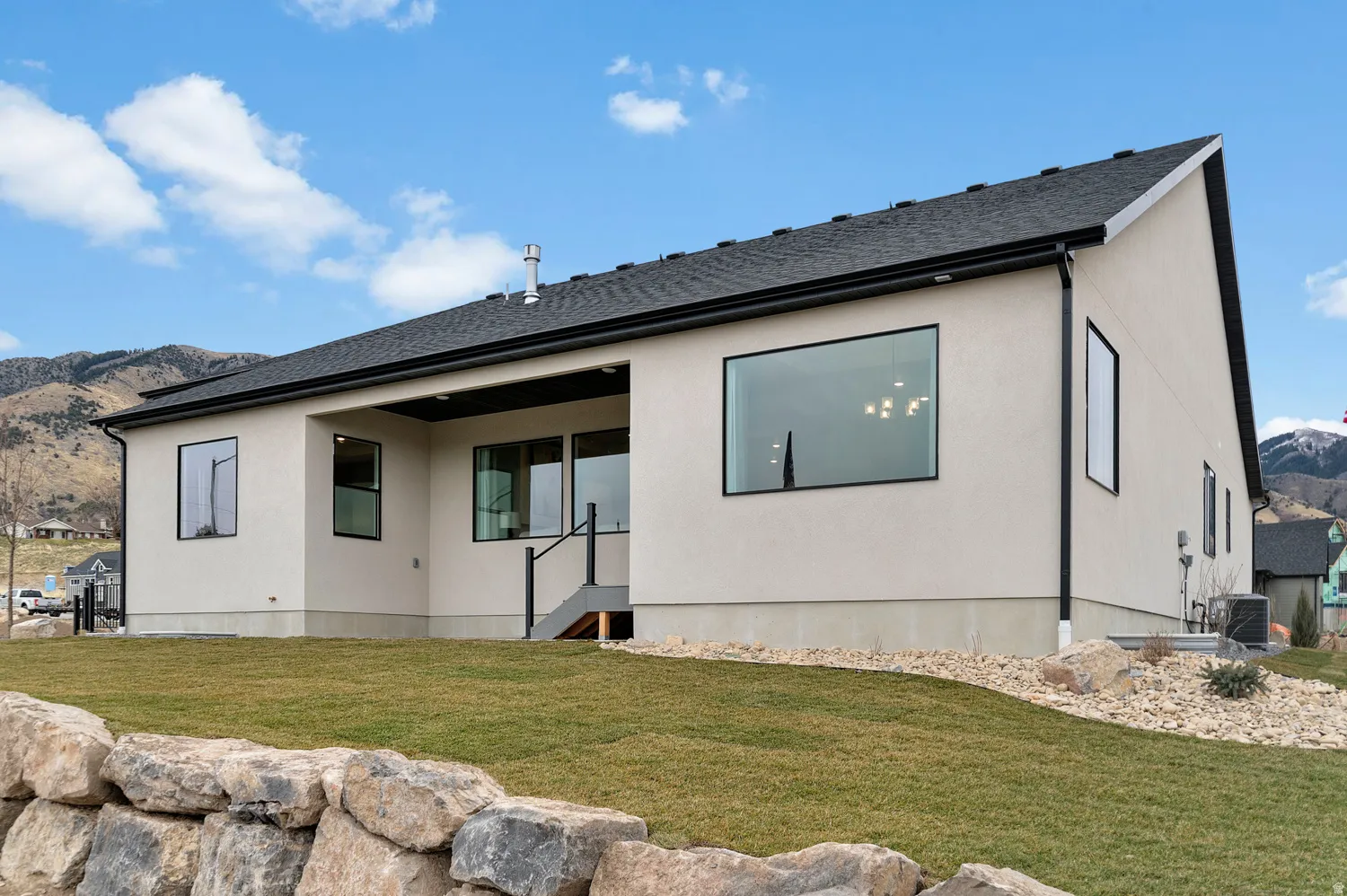 Contemporary exterior with light-colored stucco siding and dark-trimmed windows