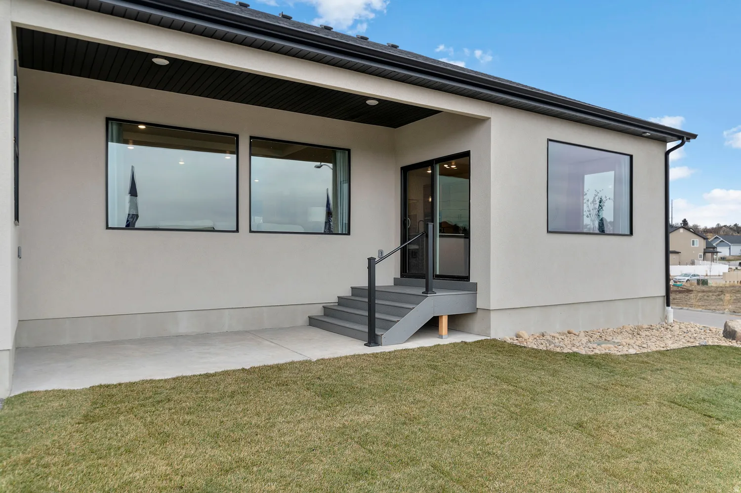 Modern stucco exterior with black-framed windows and dark soffits