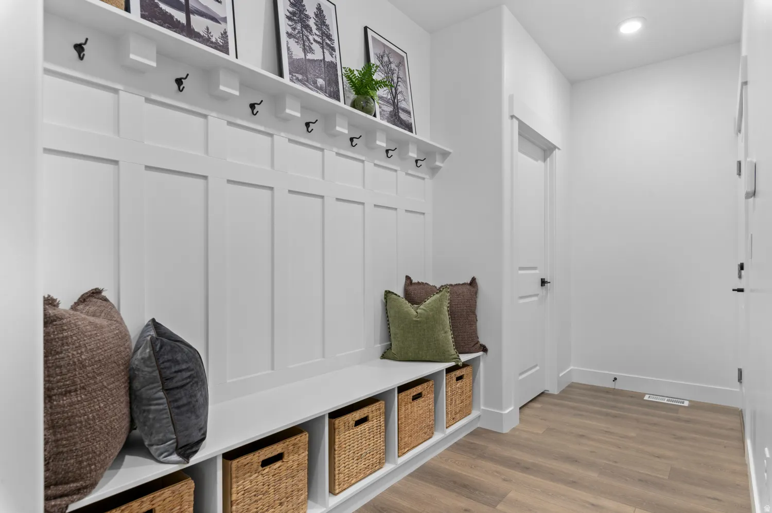 Entryway mudroom featuring white wainscoting and a built-in bench