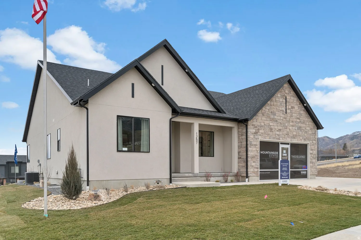 Contemporary-style residence featuring a combination of light stucco and stone veneer siding