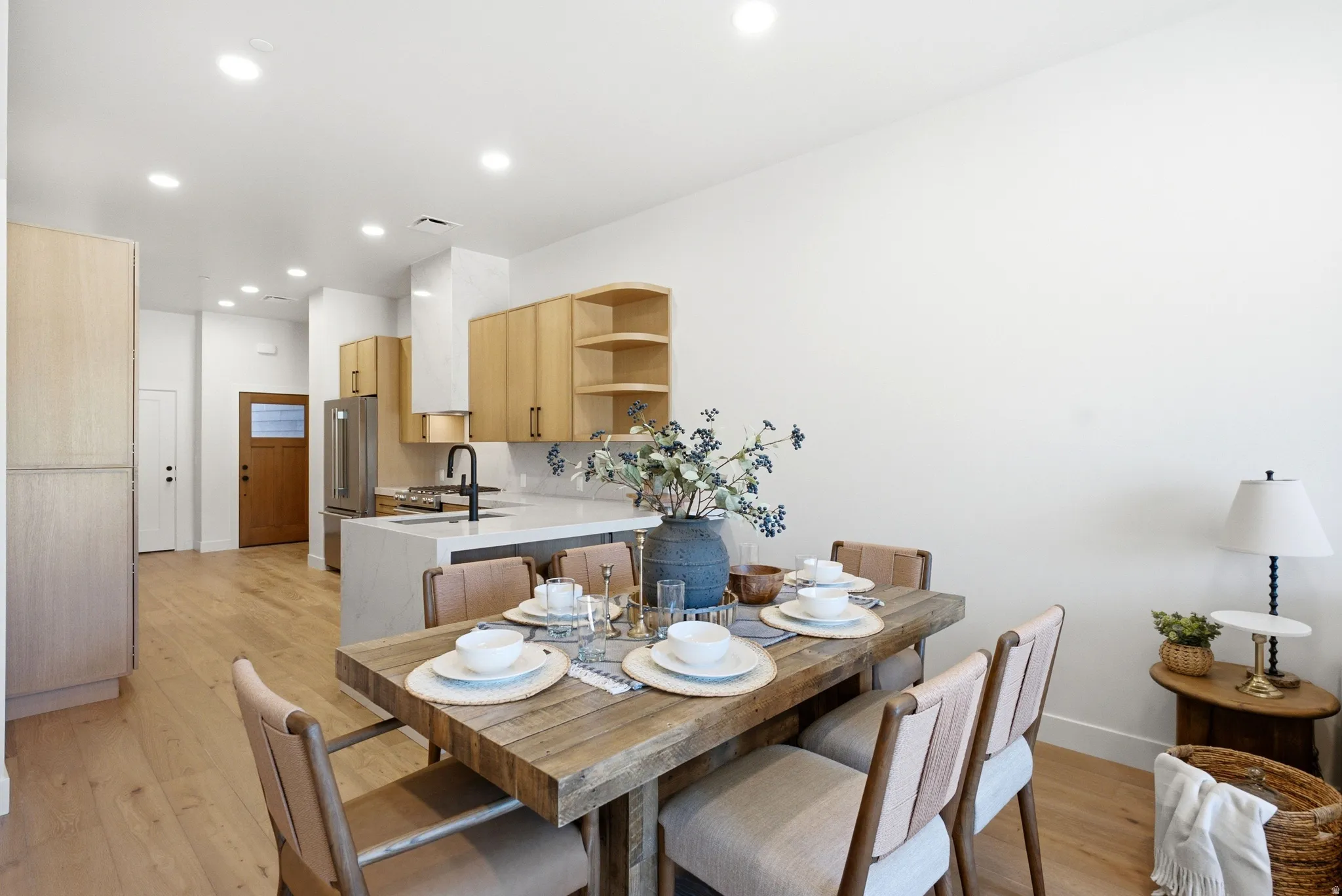 Open-concept living space featuring wood-finish flooring, recessed lighting, and a neutral color palette
