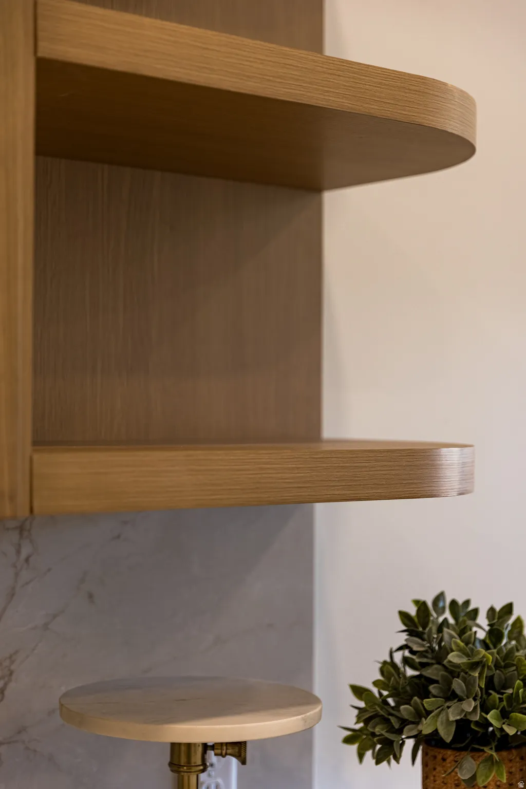 Built-in shelving featuring a light wood-finish and rounded edges