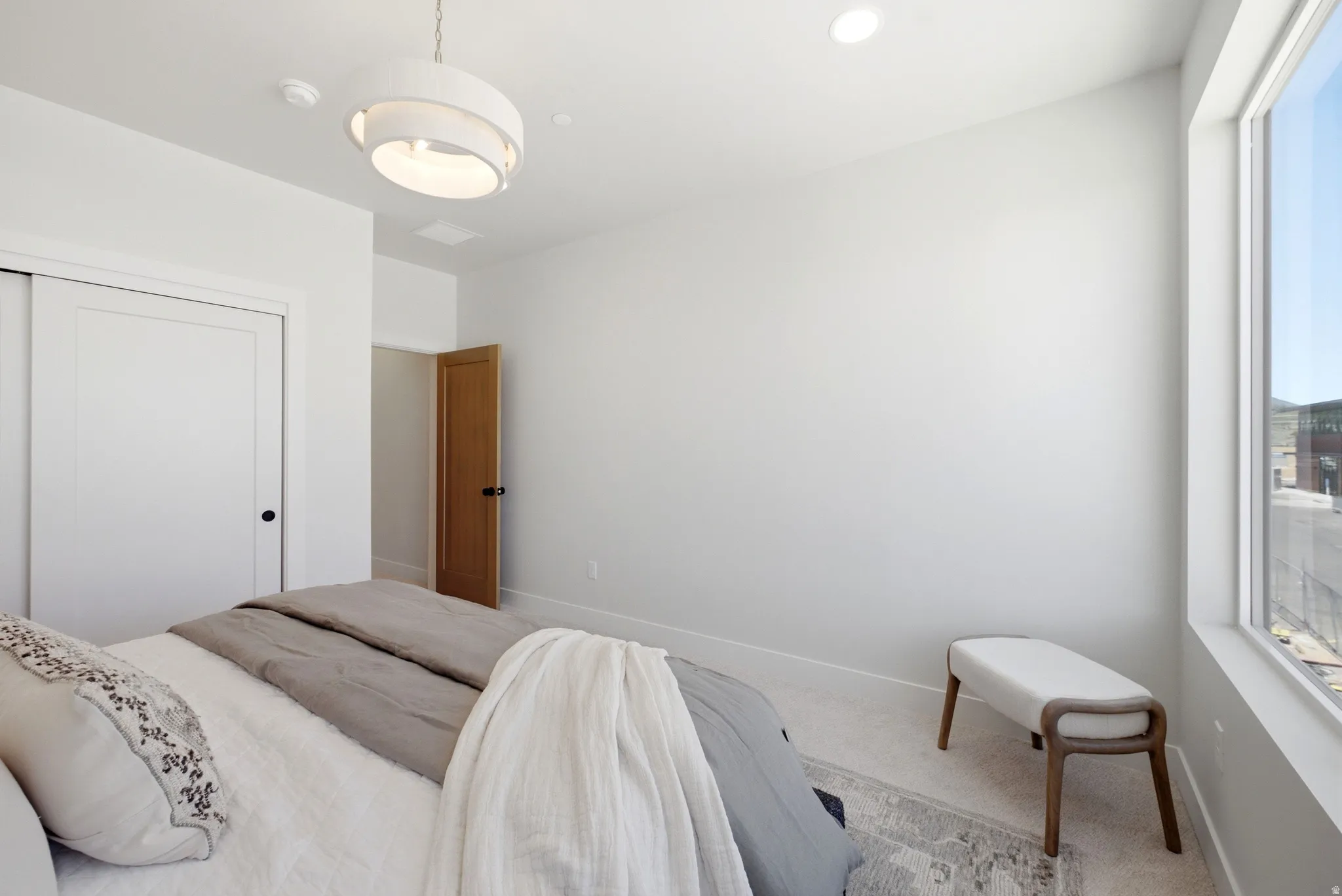 Interior room featuring a large window, recessed lighting, and a contemporary chandelier