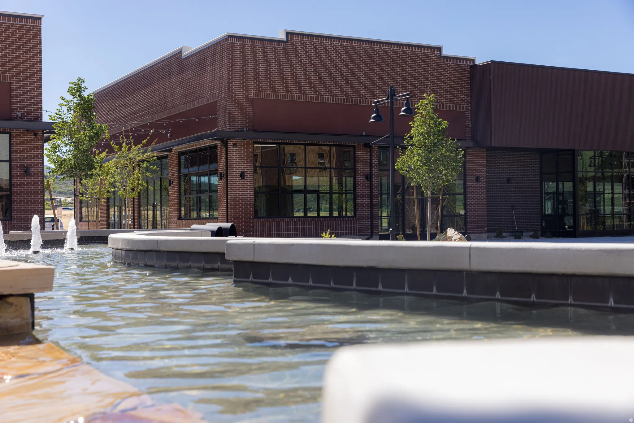 Modern commercial facade featuring dark brickwork and expansive windows