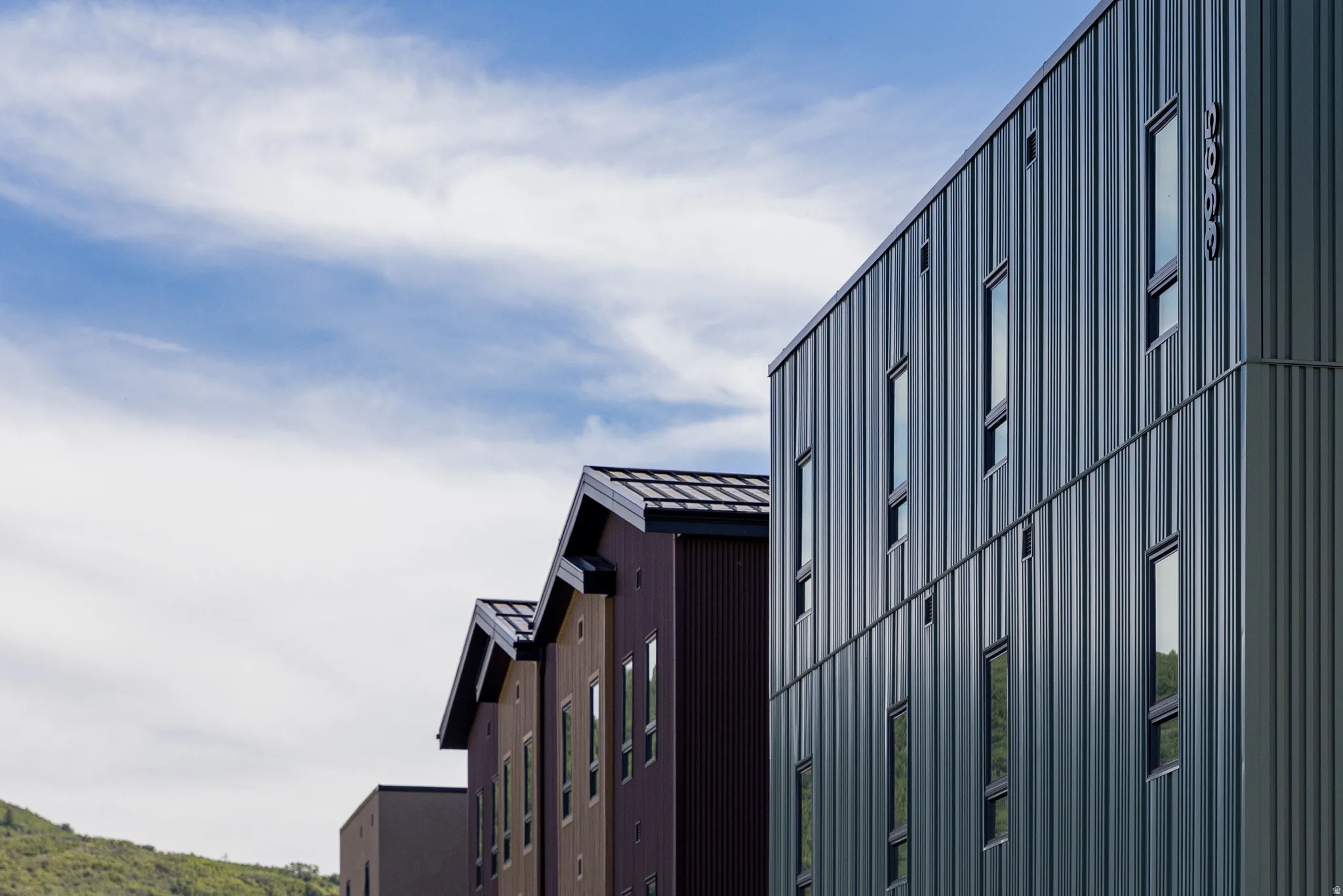 Modern architectural design featuring vertical metal siding and tall, slender windows