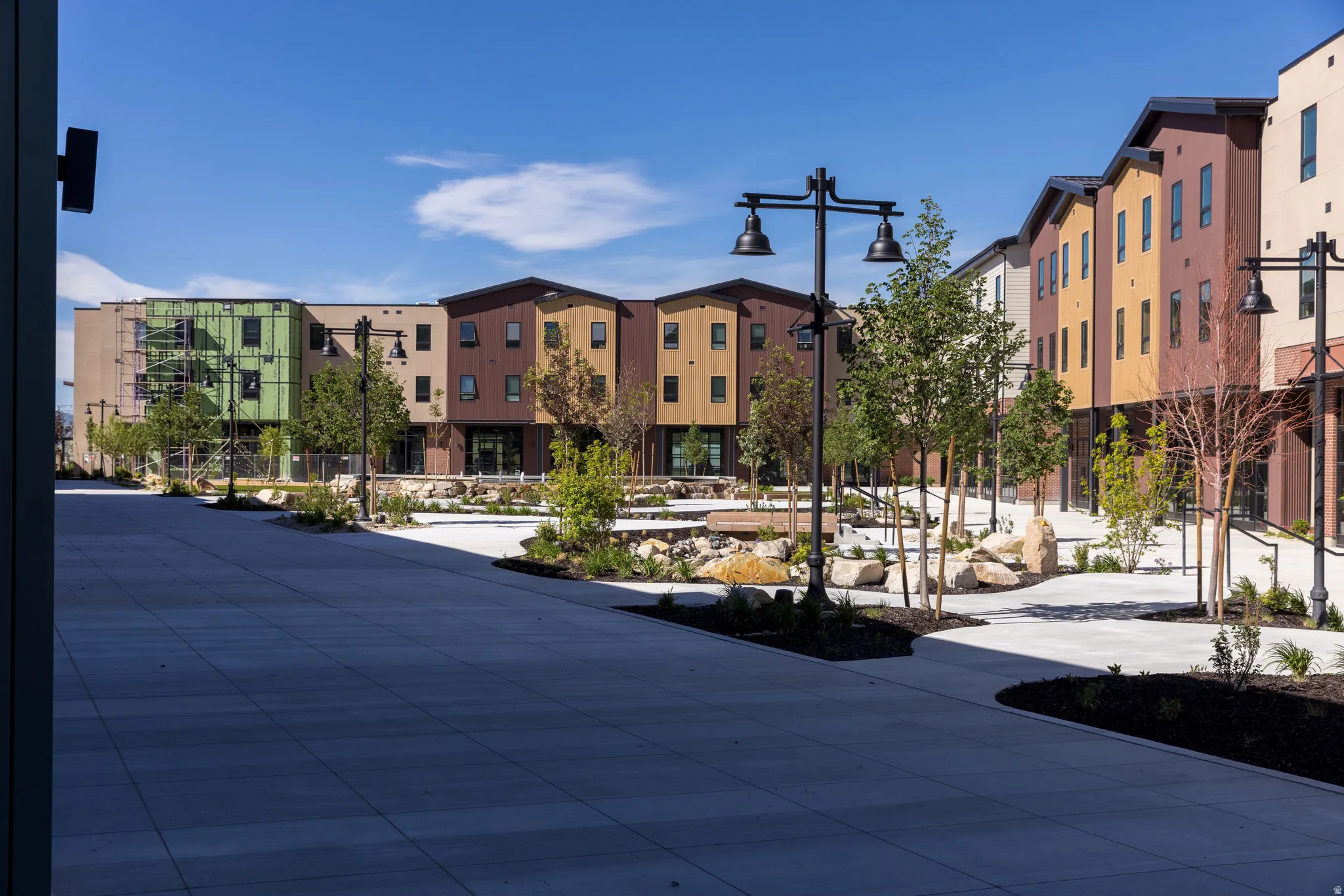 Modern multi-story buildings featuring varied exterior siding, dark-frame windows, and sloped roofs