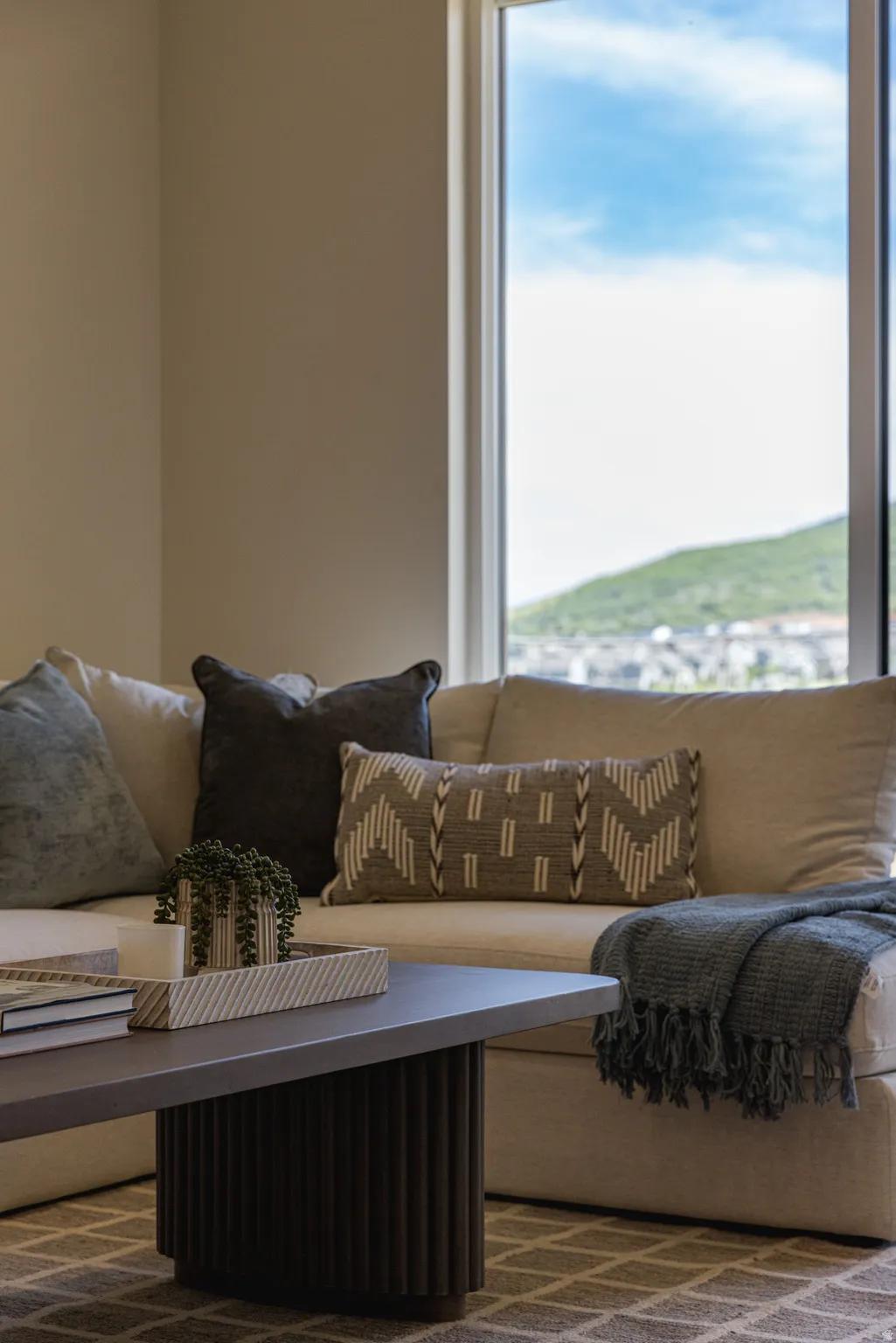 Bright living area with large window framing distant hills and urban landscape