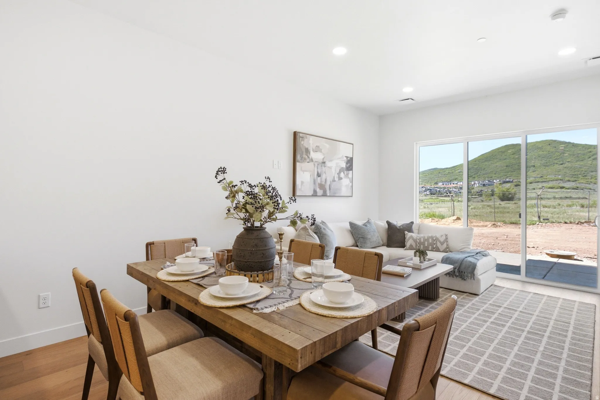 Open-concept living area featuring wood-finish flooring, recessed lighting, and a large sliding glass door