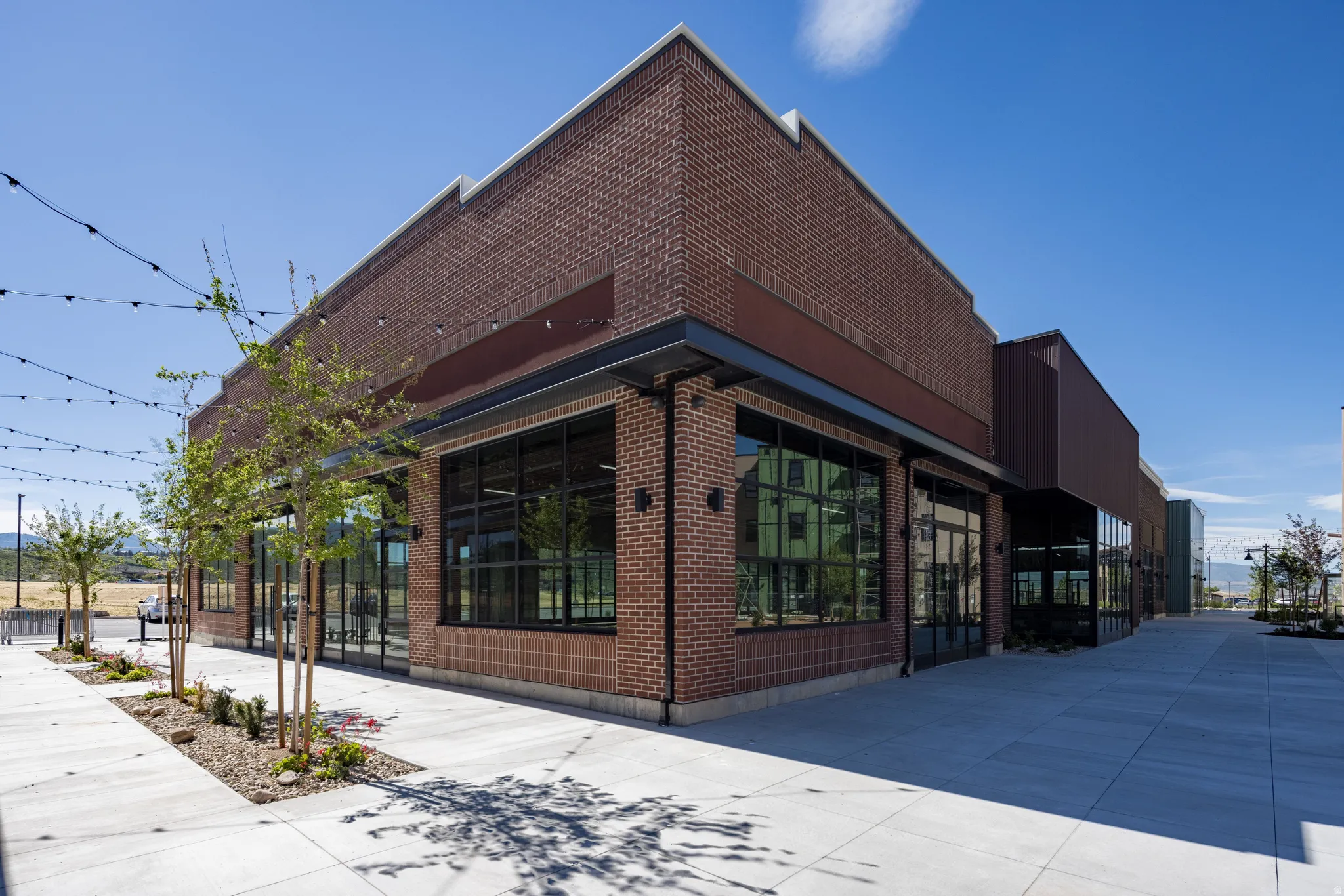 Commercial property featuring a brick exterior with large storefront windows and a dark metal awning
