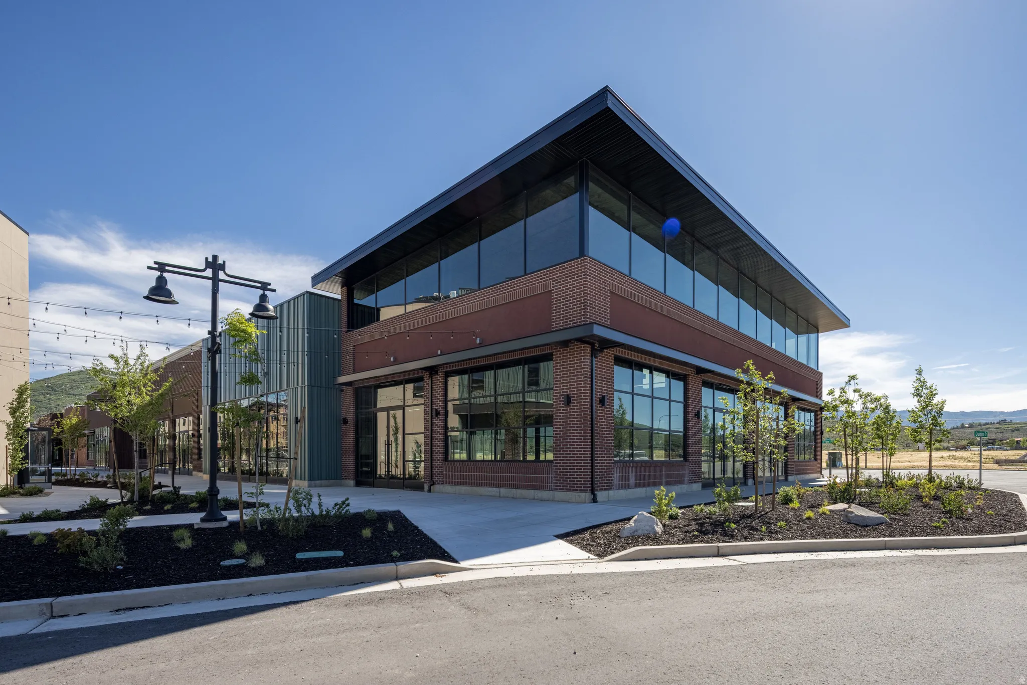 Modern commercial building featuring extensive glass window lines and brick facade