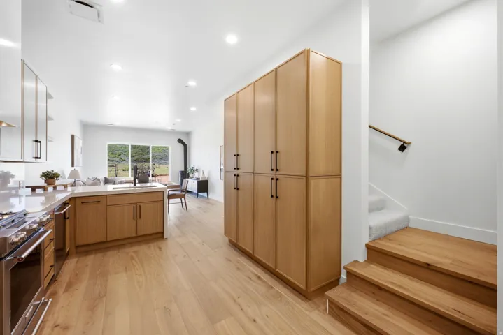 Open-concept kitchen featuring light wood-finish flooring, recessed lighting, and a suite of stainless steel appliances