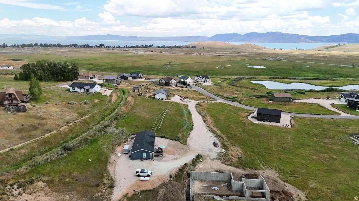 Elevated lot featuring a partially constructed foundation, offering expansive landscape views and a visible body of water