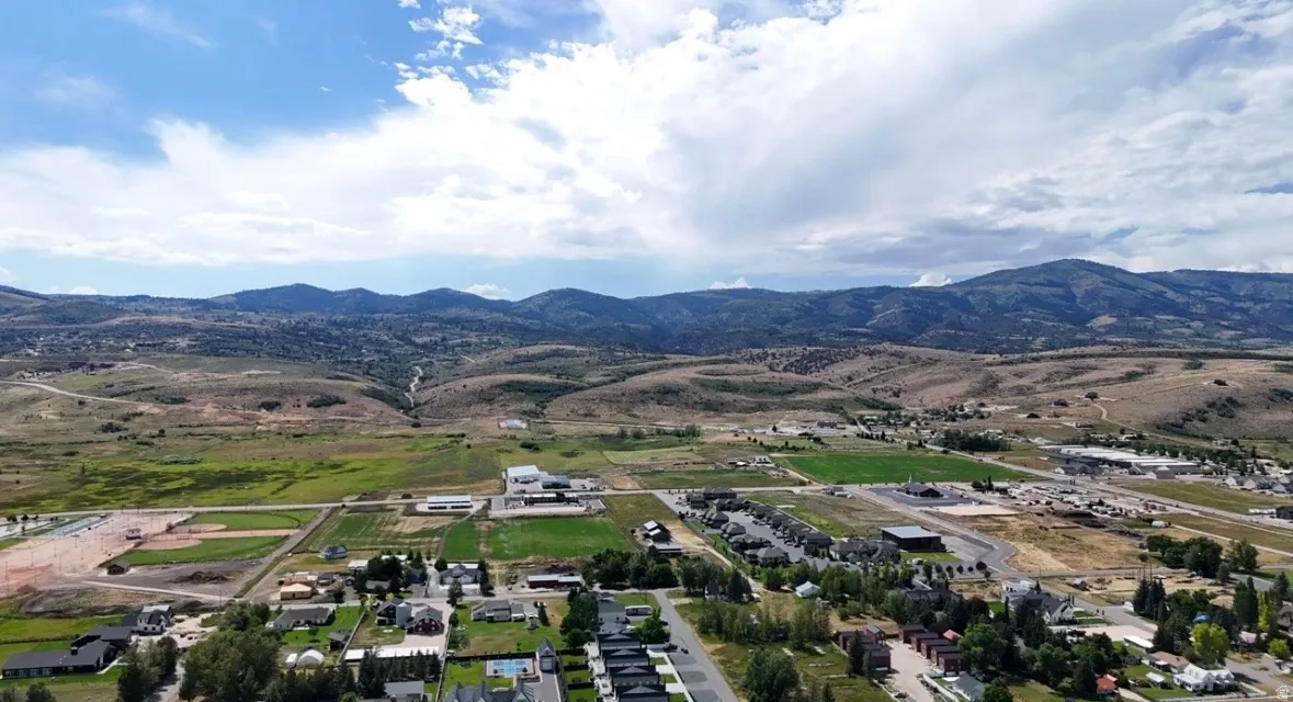 Expansive high desert landscape featuring distant mountain ranges and scattered residential areas