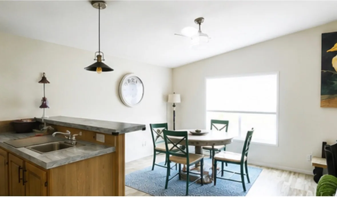 Kitchen island featuring an undermount sink, a bar-height counter, and wood-finish cabinetry
