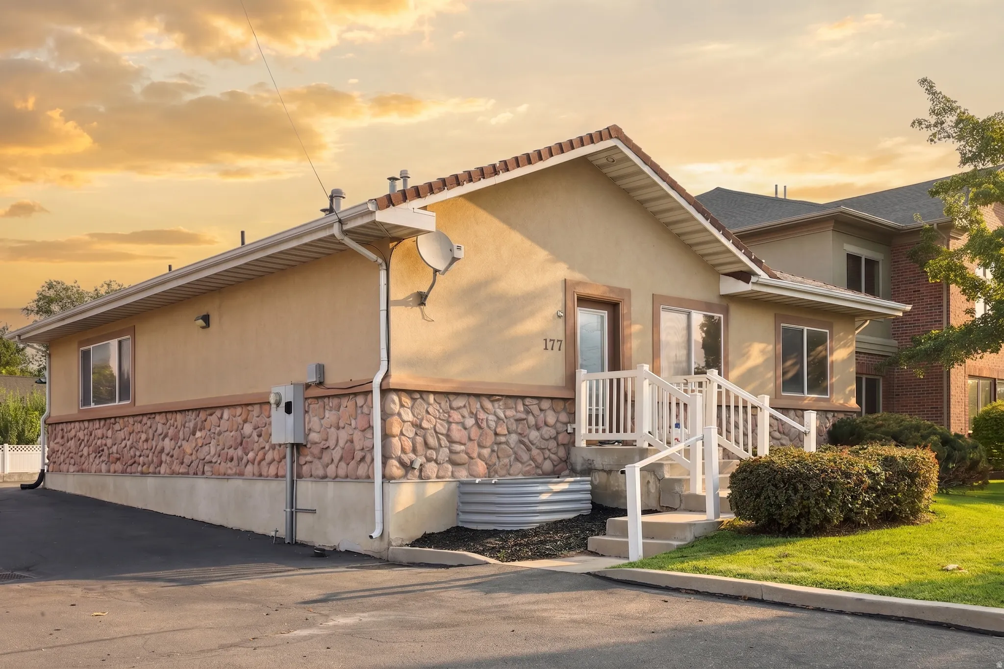 Exterior featuring stucco siding, stone accents, and a tile roof