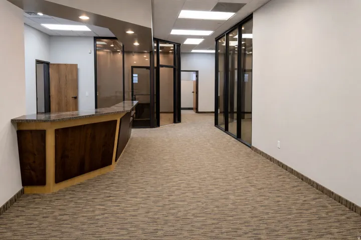 Reception area featuring a wood-panel reception desk with a stone-look countertop