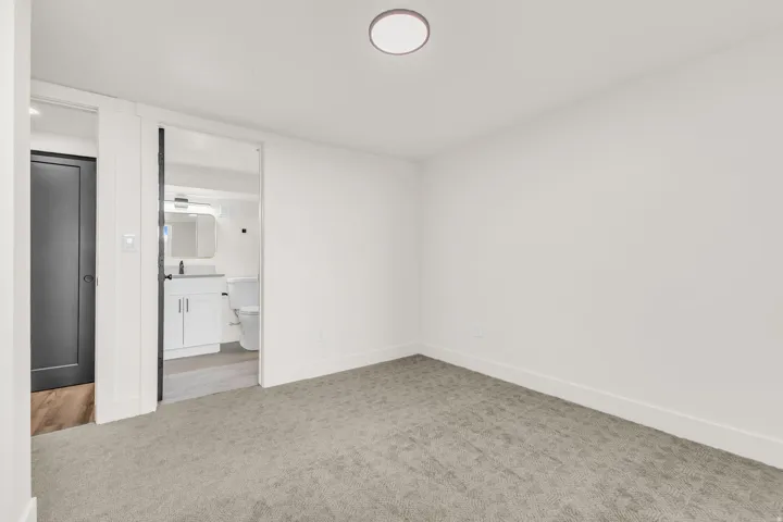 Carpeted room featuring a ceiling-mounted light fixture and white baseboards