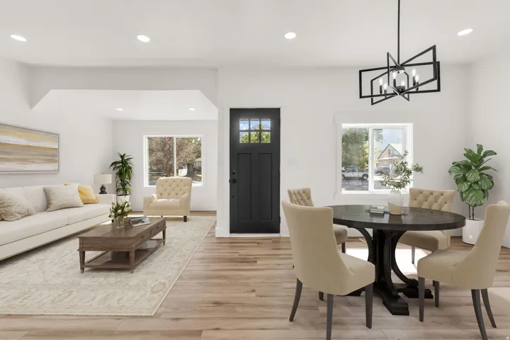 Open-concept living area featuring wood-finish flooring, recessed lighting, and a dark paneled entry door with glass inserts