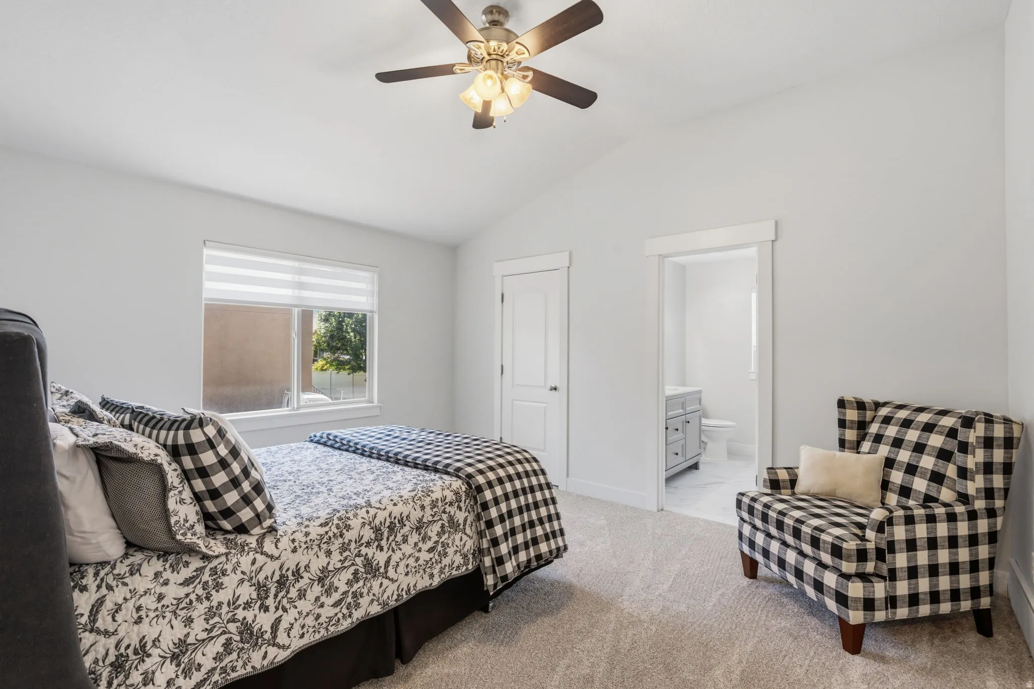 Vaulted ceiling bedroom featuring a ceiling fan with integrated lighting, window with horizontal blinds, and carpet flooring