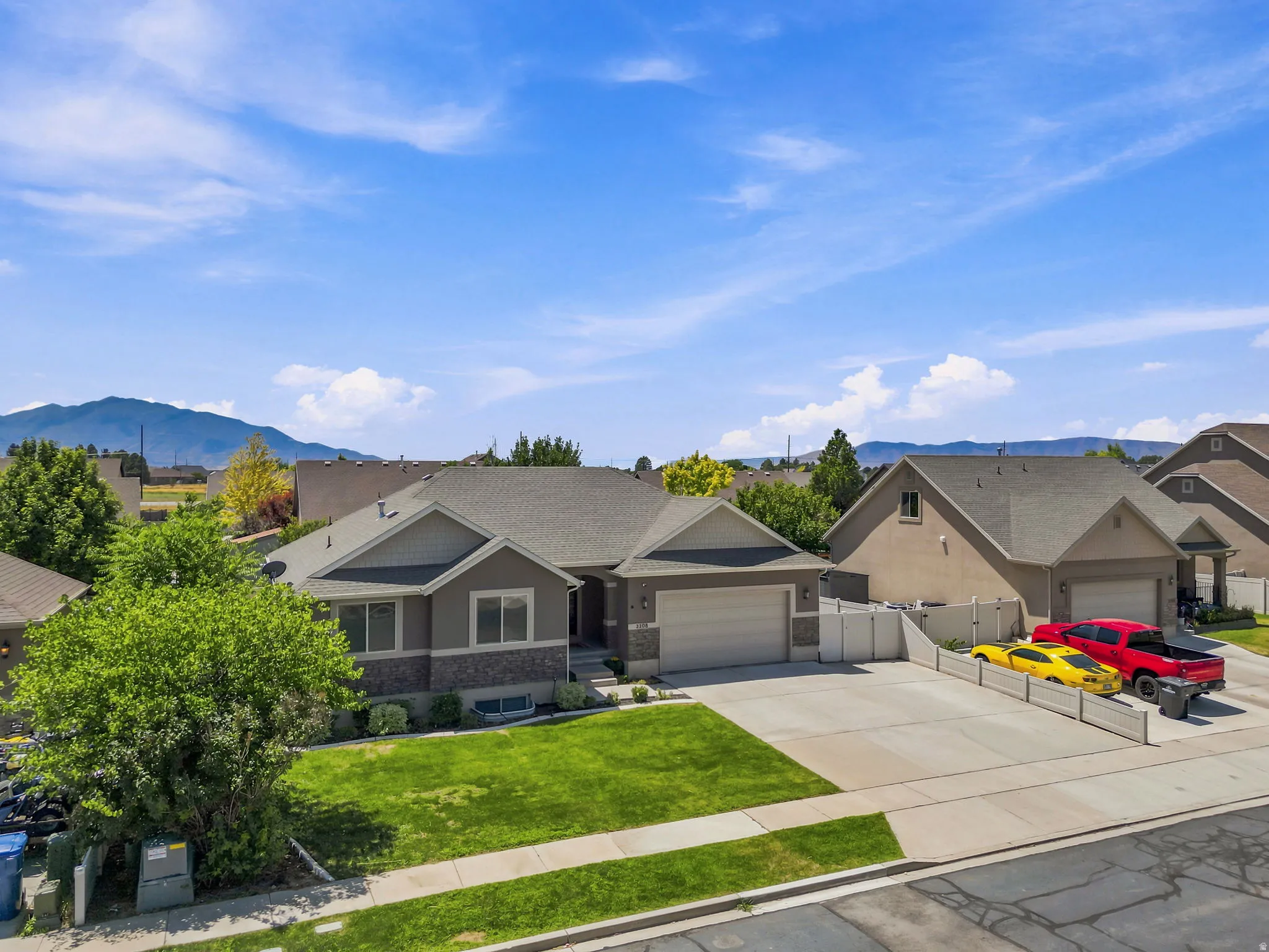 Single-story residence featuring a gray exterior with stone accents, a two-car garage, and a concrete driveway