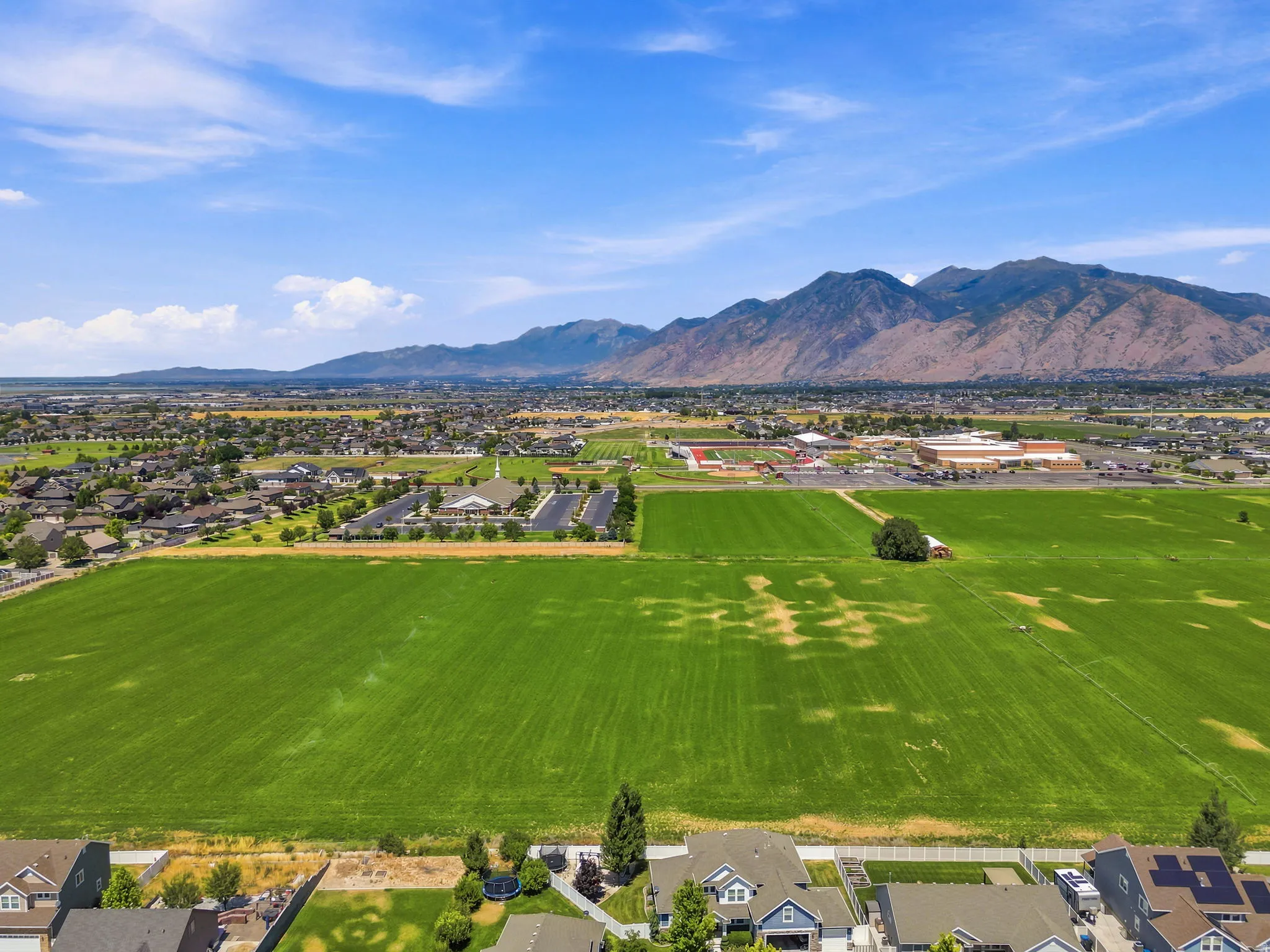 Expansive green fields bordering residential properties