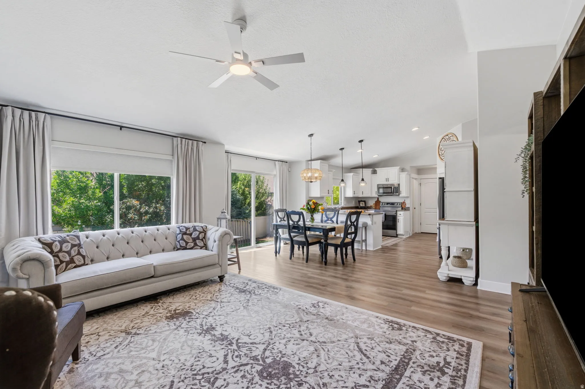 Spacious living area featuring wood-finish flooring and vaulted ceilings
