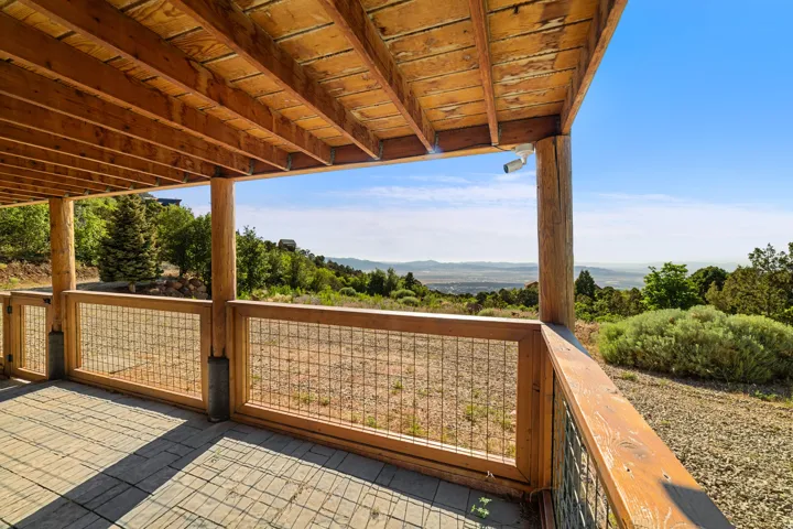 Expansive outdoor deck featuring wood-finish flooring, natural wood posts, and wire mesh railings