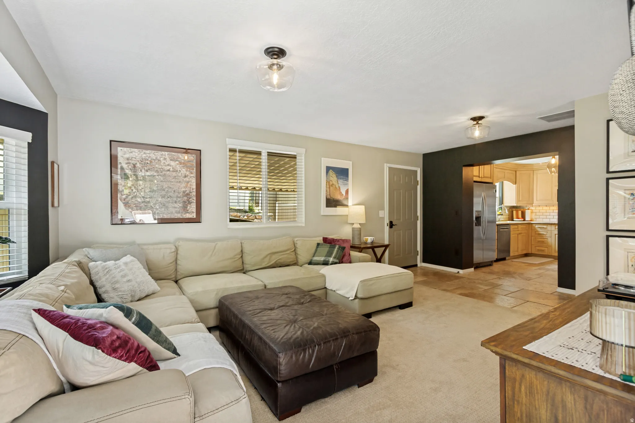 Carpeted living area featuring light-toned walls with a dark accent wall