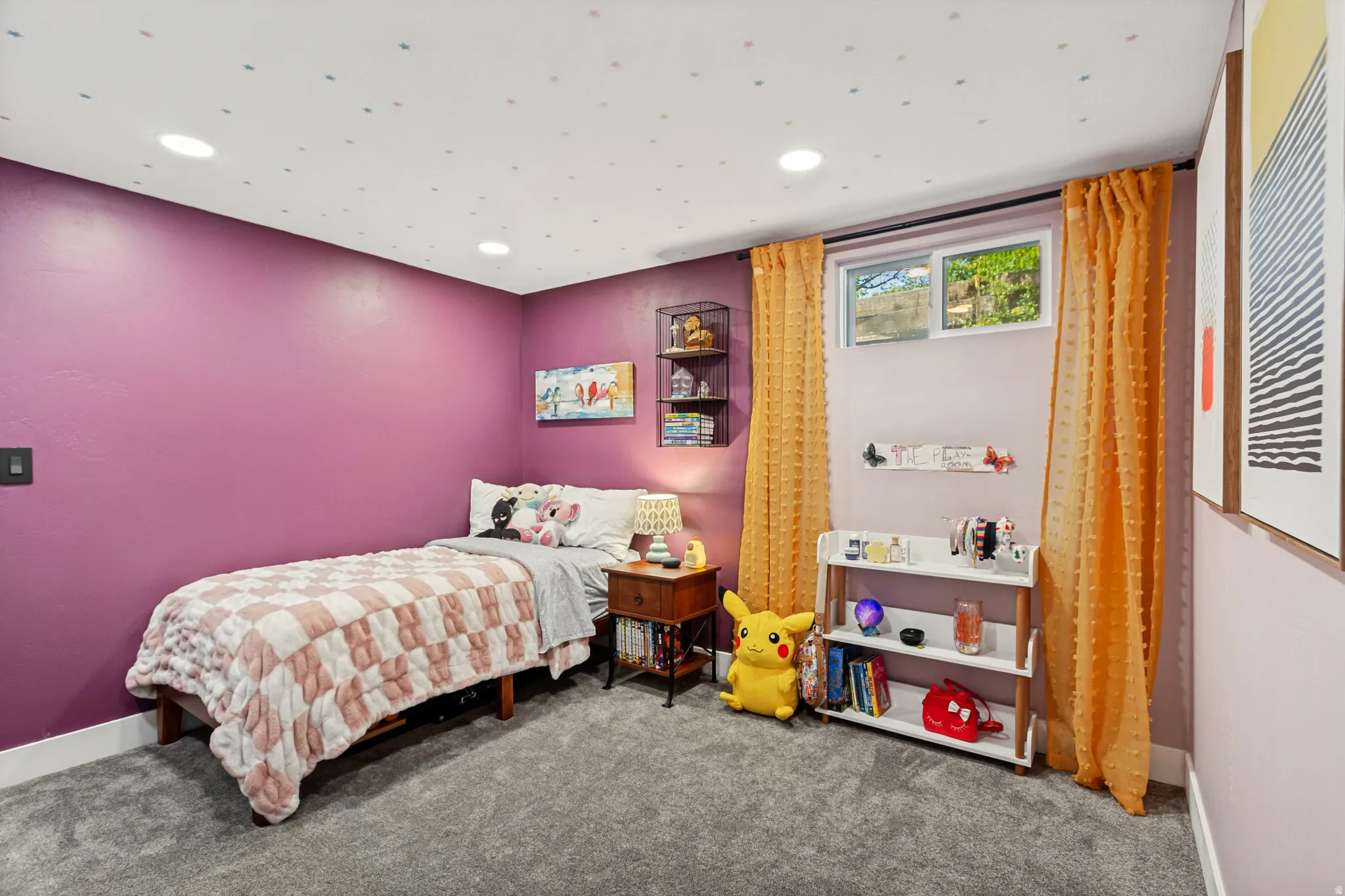 Recessed lighting illuminates a room with vibrant purple walls and gray carpeting