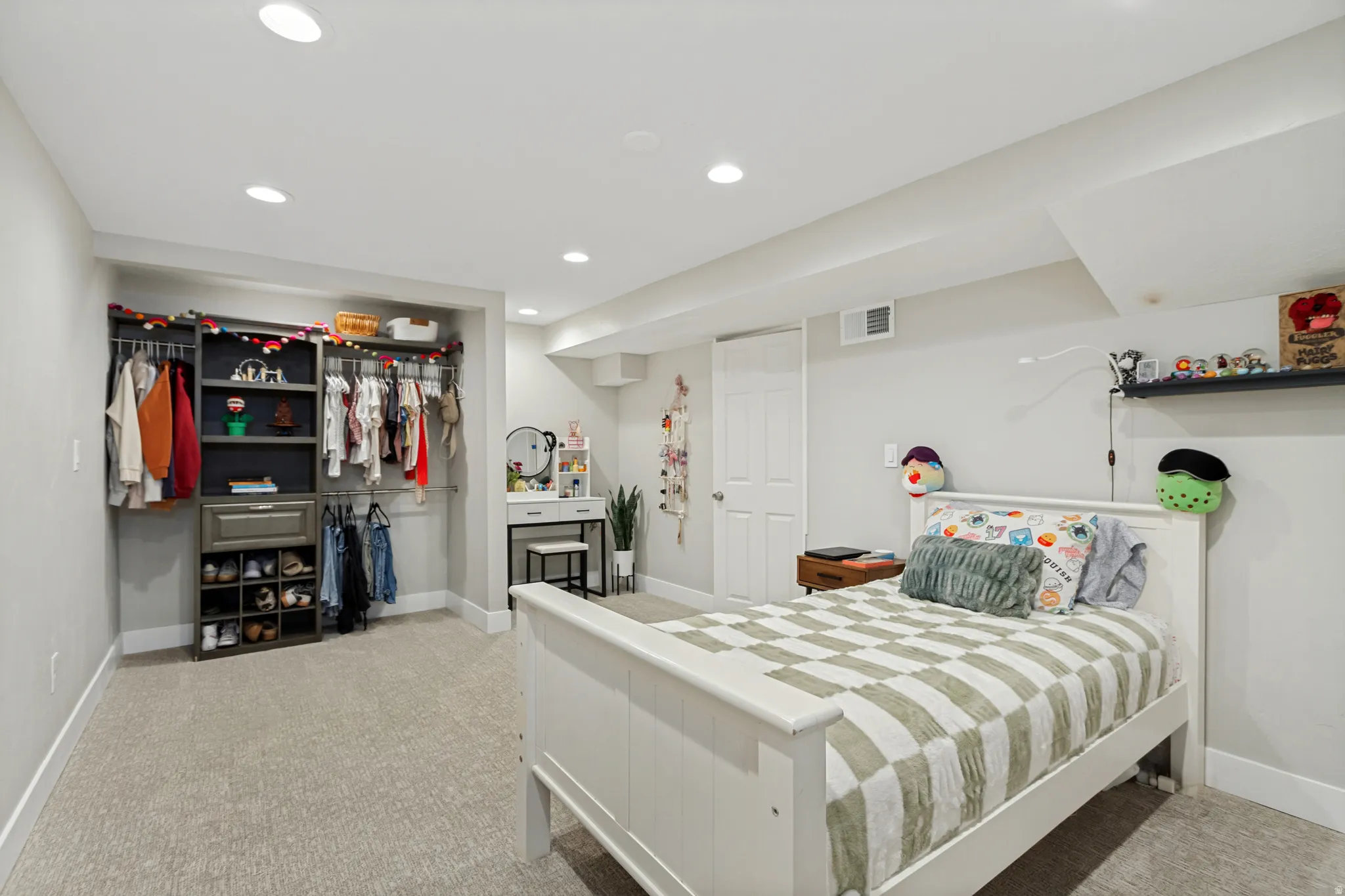 Carpeted room featuring recessed lighting, a built-in closet organization system, a white paneled door, and a wall-mounted shelf