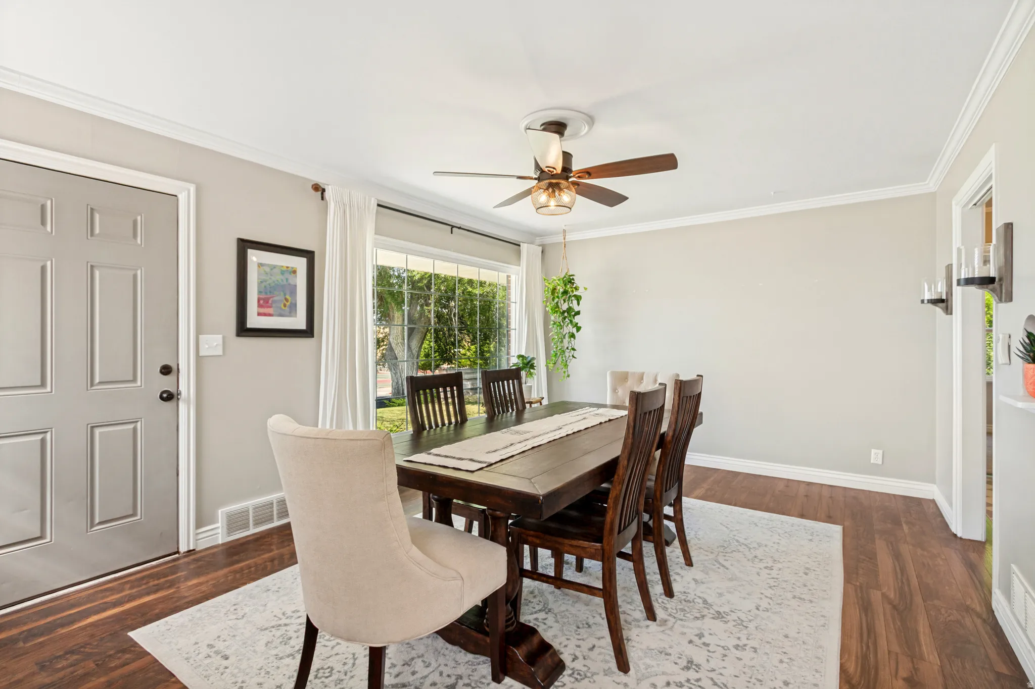 Expansive room featuring wood-finish flooring, light grey walls, and white crown molding