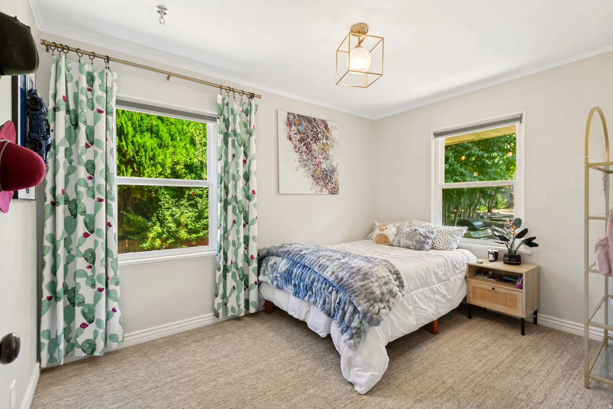Bedroom featuring two windows, crown molding, and neutral carpeting