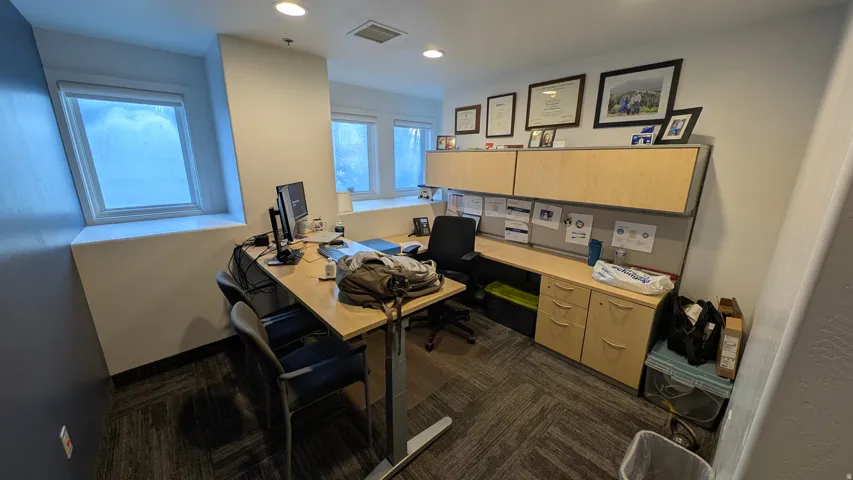 Office space featuring multiple windows, recessed lighting, modular cabinetry, and patterned carpet