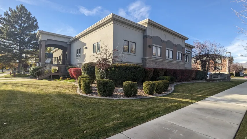 Stucco exterior with stone accent siding, multiple windows, and a covered entry porch